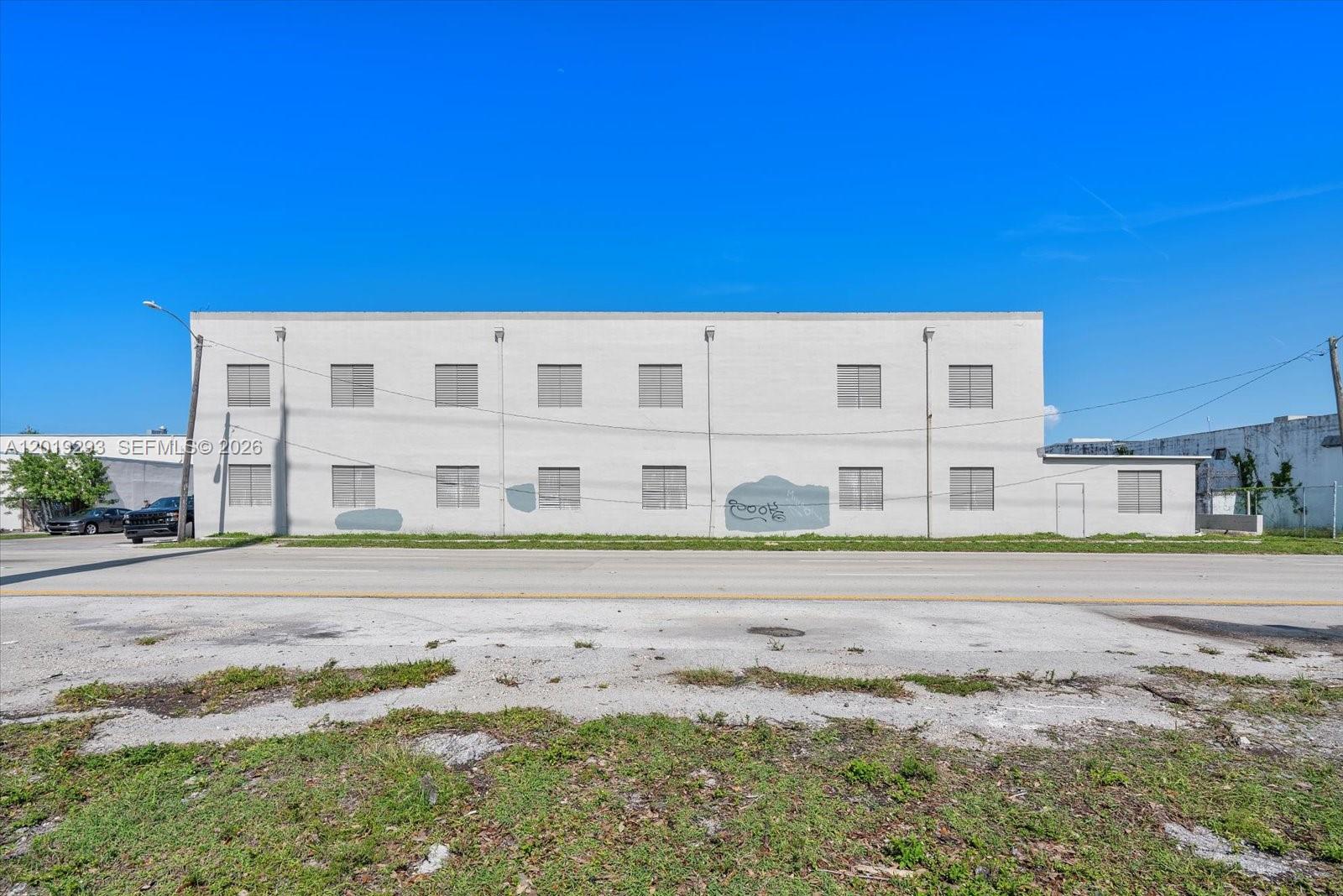 The exterior of a two-story commercial building features a plain white facade with shuttered windows — 2040 Liberty St, Hollywood FL 33020, HOLLYWOOD, FL
