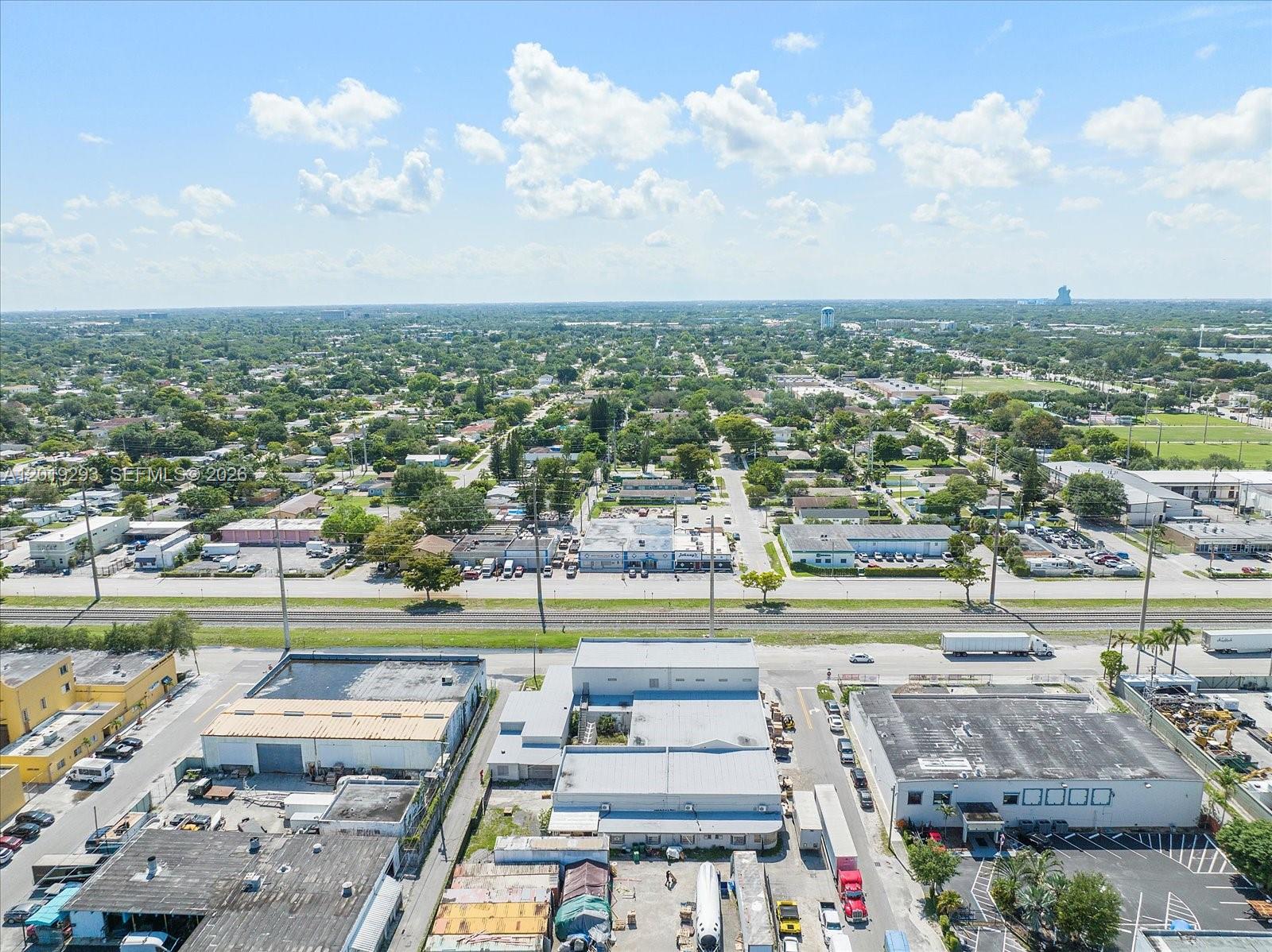 An aerial view shows industrial buildings, a railroad track, and a surrounding residential neighborhood — 2040 Liberty St, Hollywood FL 33020, HOLLYWOOD, FL