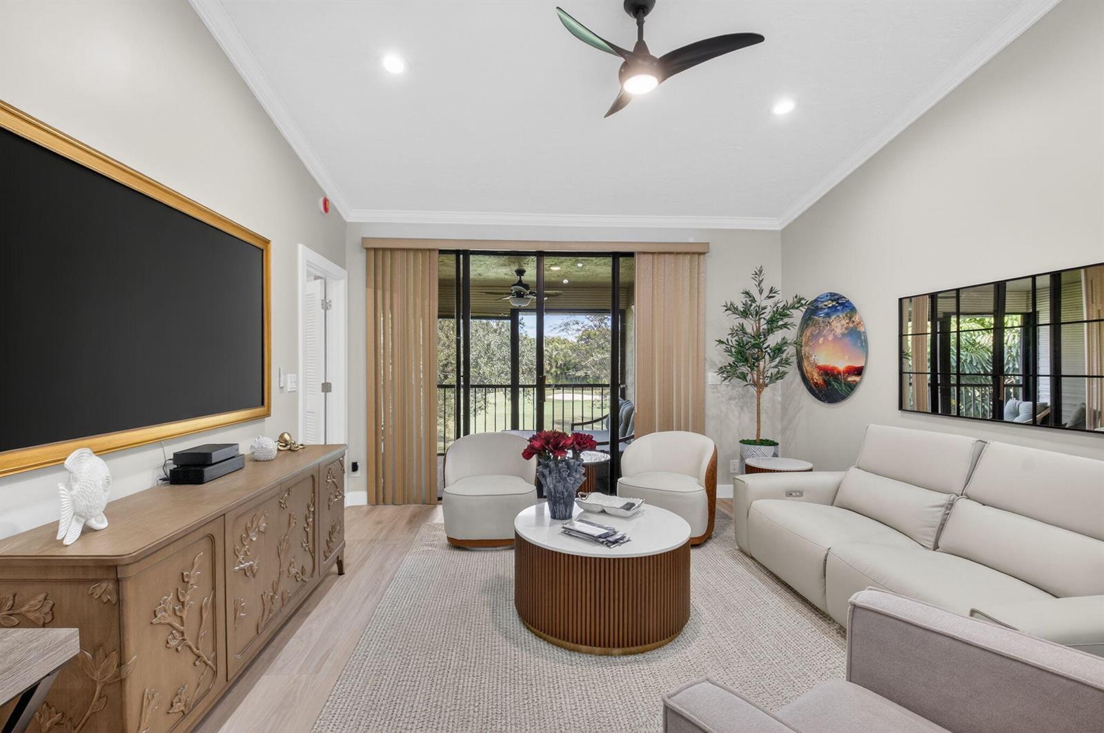 A living room features a large television, a white sofa, two armchairs, and a coffee table — 7455 Glendevon Lane # 206, Delray Beach FL 33446, DELRAY BEACH, FL