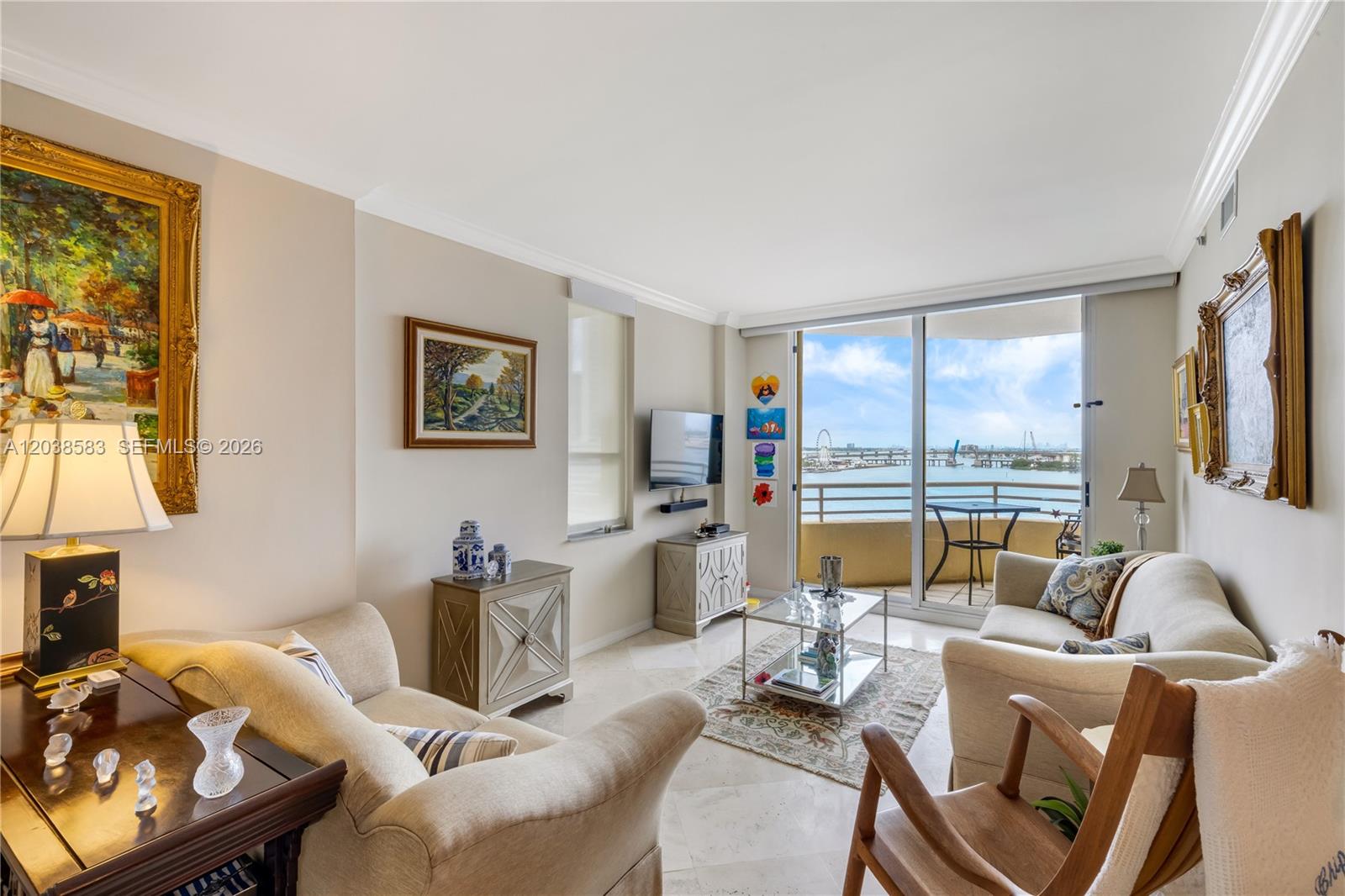 A living room features beige sofas, a glass coffee table, and a balcony overlooking water — 888 Brickell Key Dr # 1010, Miami FL 33131, MIAMI, FL
