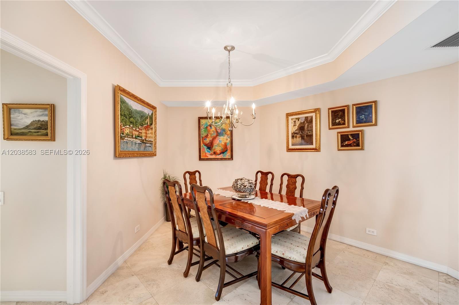 A dining room features a wooden table, six chairs, a chandelier, and several framed paintings — 888 Brickell Key Dr # 1010, Miami FL 33131, MIAMI, FL