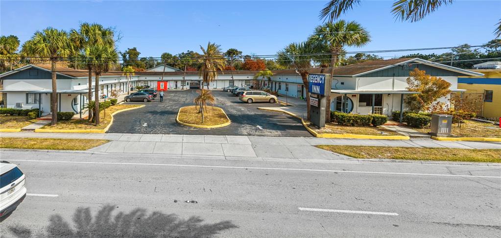 An exterior view of a single-story motel with a parking lot and palm trees — 619 N RIDGEWOOD AVENUE, DAYTONA BEACH, FL