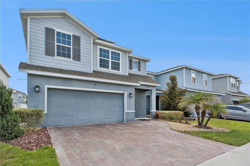 A two-story house with a gray stucco and siding exterior and a paved driveway — 4406 SILVER CREEK STREET, KISSIMMEE, FL