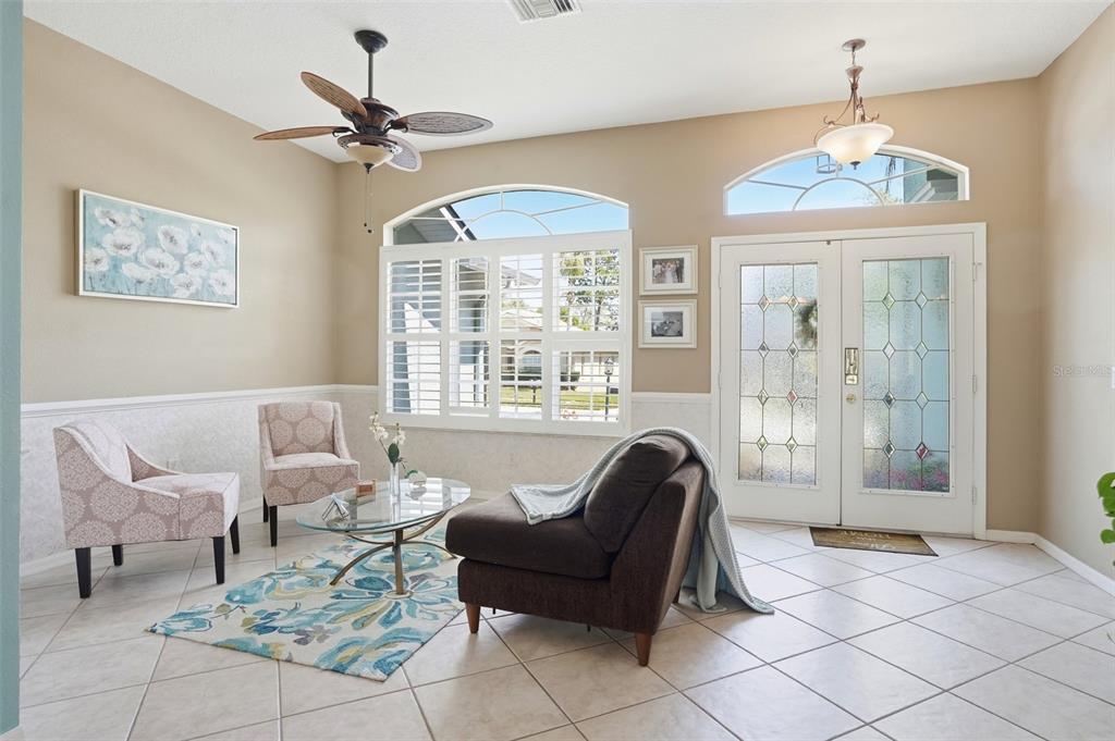 A living room features tile floors, a ceiling fan, a glass coffee table, and double doors — 11408 ALDEN COURT, HUDSON, FL