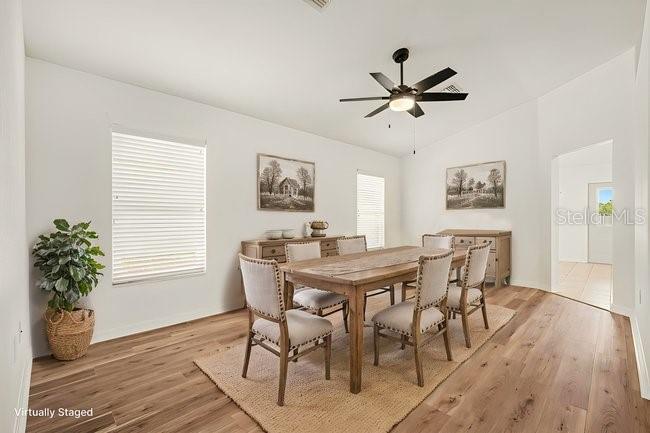 A dining room features a wooden table, six chairs, a ceiling fan, and hardwood floors — 31331 SATINLEAF RUN, BROOKSVILLE, FL