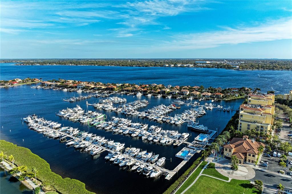 An aerial view shows a large marina filled with boats next to waterfront residential buildings — 102 RIVIERA DUNES WAY UNIT N57, PALMETTO, FL