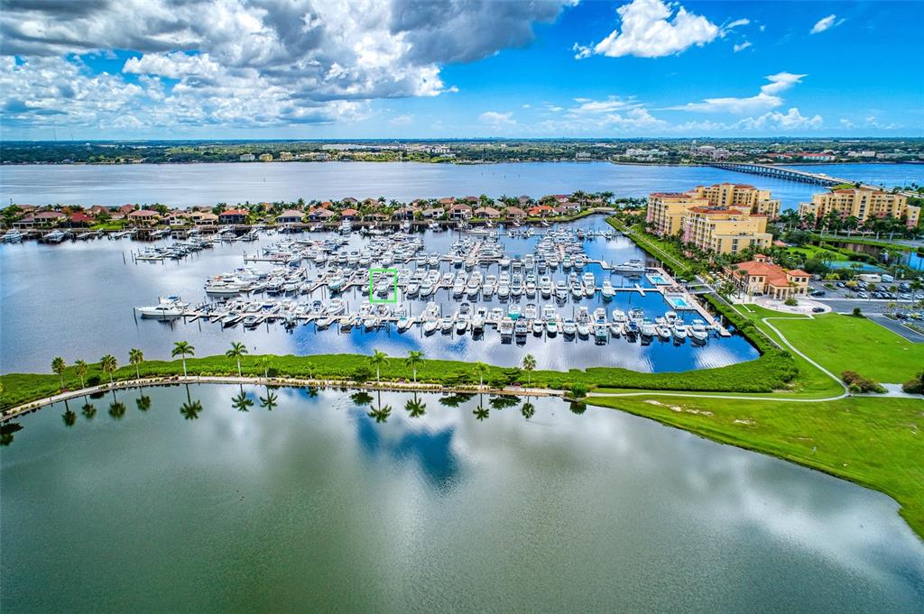 An aerial view shows a large marina filled with boats next to a residential complex — 102 RIVIERA DUNES WAY UNIT N57, PALMETTO, FL