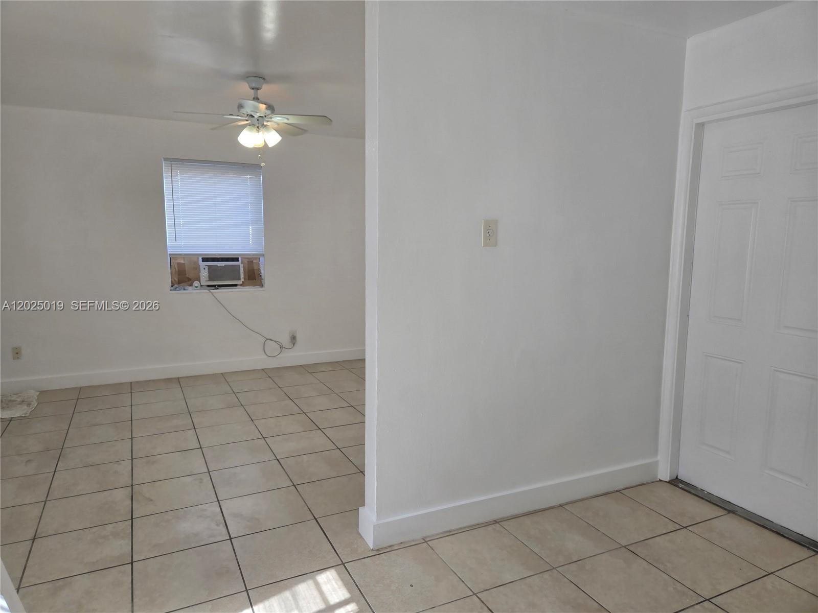 An interior view shows a tiled room with a ceiling fan and a window unit — 408 NW 8th St # 408, Hallandale Beach FL 33009, HALLANDALE BEACH, FL