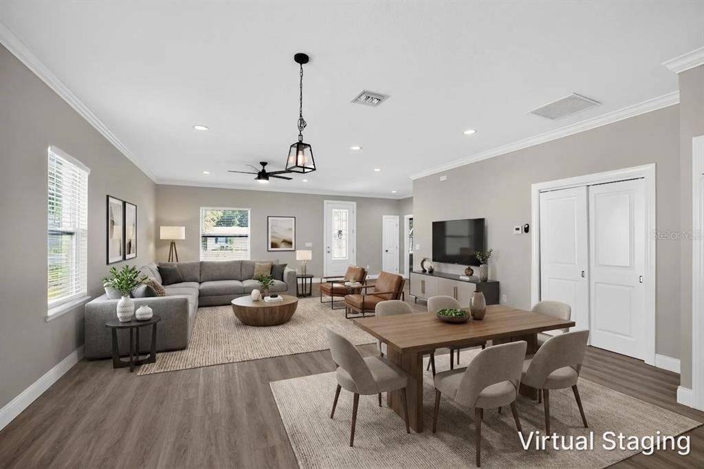 A virtually staged open-concept living and dining area features gray walls and wood-look flooring — 7977 49TH AVENUE N, ST PETERSBURG, FL