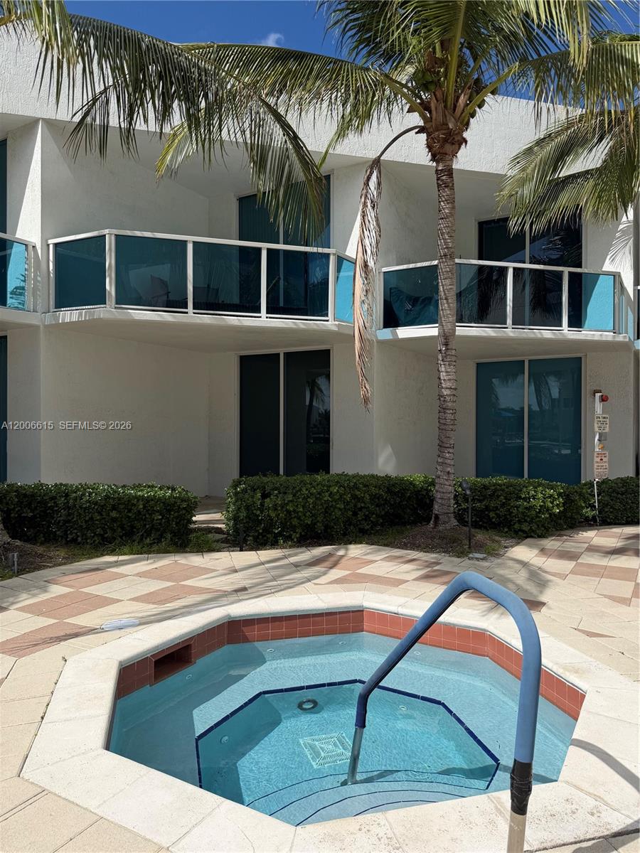 A hot tub sits on a tiled patio in front of a multi-story building — 1945 S Ocean Dr # 603, Hallandale Beach FL 33009, HALLANDALE BEACH, FL