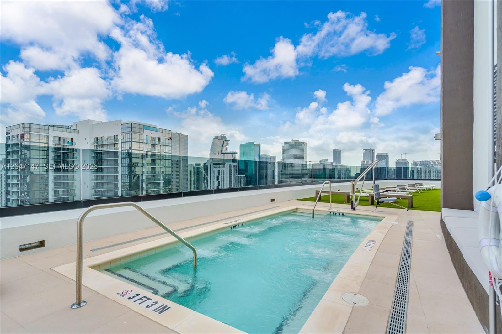 A rooftop hot tub with a metal railing overlooks a city skyline under a blue sky — 225 N Miami Ave # 1107, Miami FL 33128, MIAMI, FL