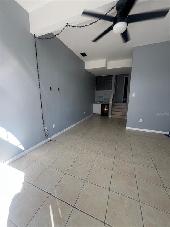 A living room with light blue walls, tile flooring, and a ceiling fan with a chain — 215 GOLDSTEIN STREET UNIT 4, PUNTA GORDA, FL