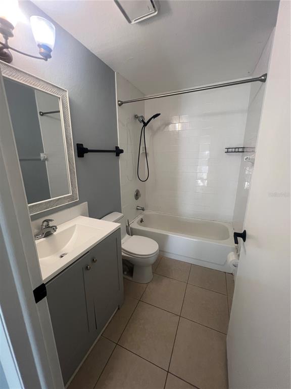 A bathroom features a gray vanity, a white toilet, and a bathtub with white tile — 215 GOLDSTEIN STREET UNIT 4, PUNTA GORDA, FL