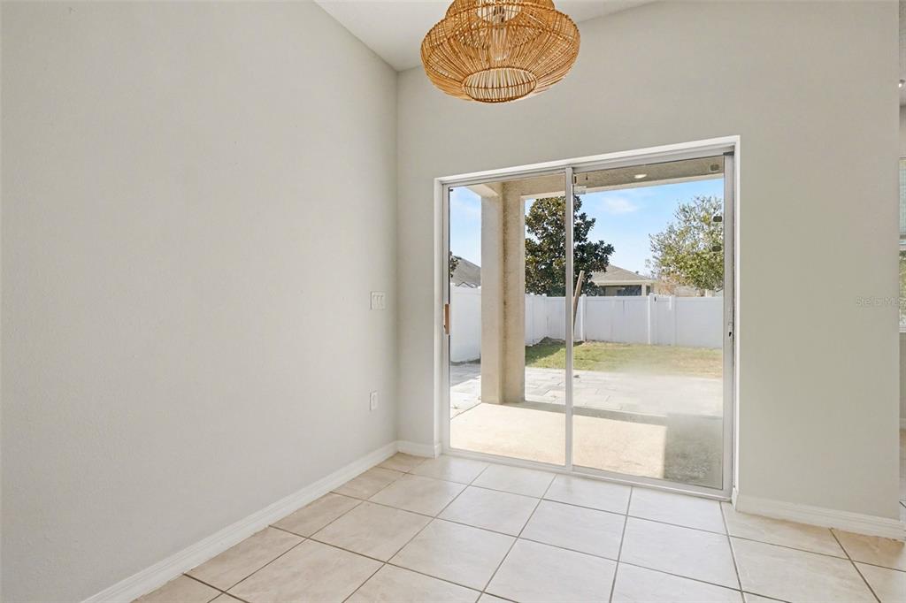 An empty room features light tile flooring, white walls, and a dark green accent wall — 2735 ROWAN STREET, TAVARES, FL