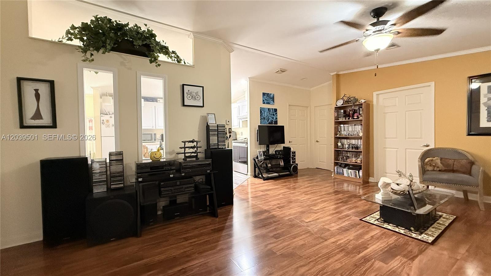 A living room features wood-look flooring, a ceiling fan, and a media console — 8631 SW 18th Pl, Davie FL 33324, DAVIE, FL