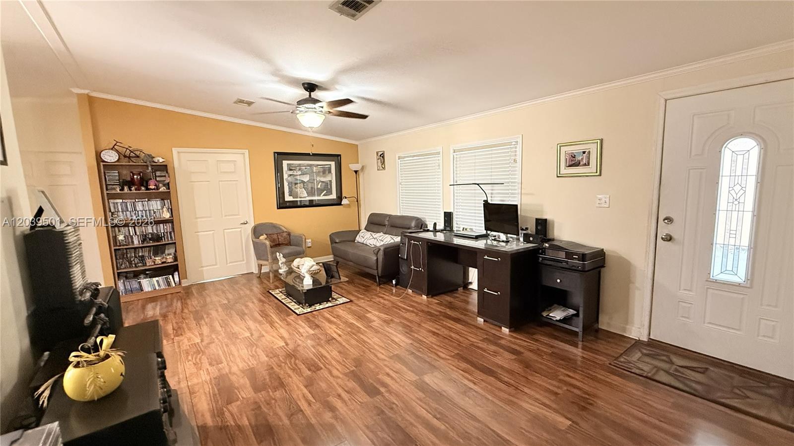 This living room features wood-look flooring, a ceiling fan, a desk, and a sofa — 8631 SW 18th Pl, Davie FL 33324, DAVIE, FL