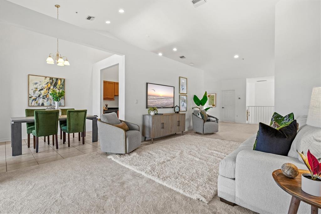 A living room with carpeted floors, a dining area, and neutral furniture — 2309 JESSIE HARBOR DRIVE UNIT 2402, OSPREY, FL