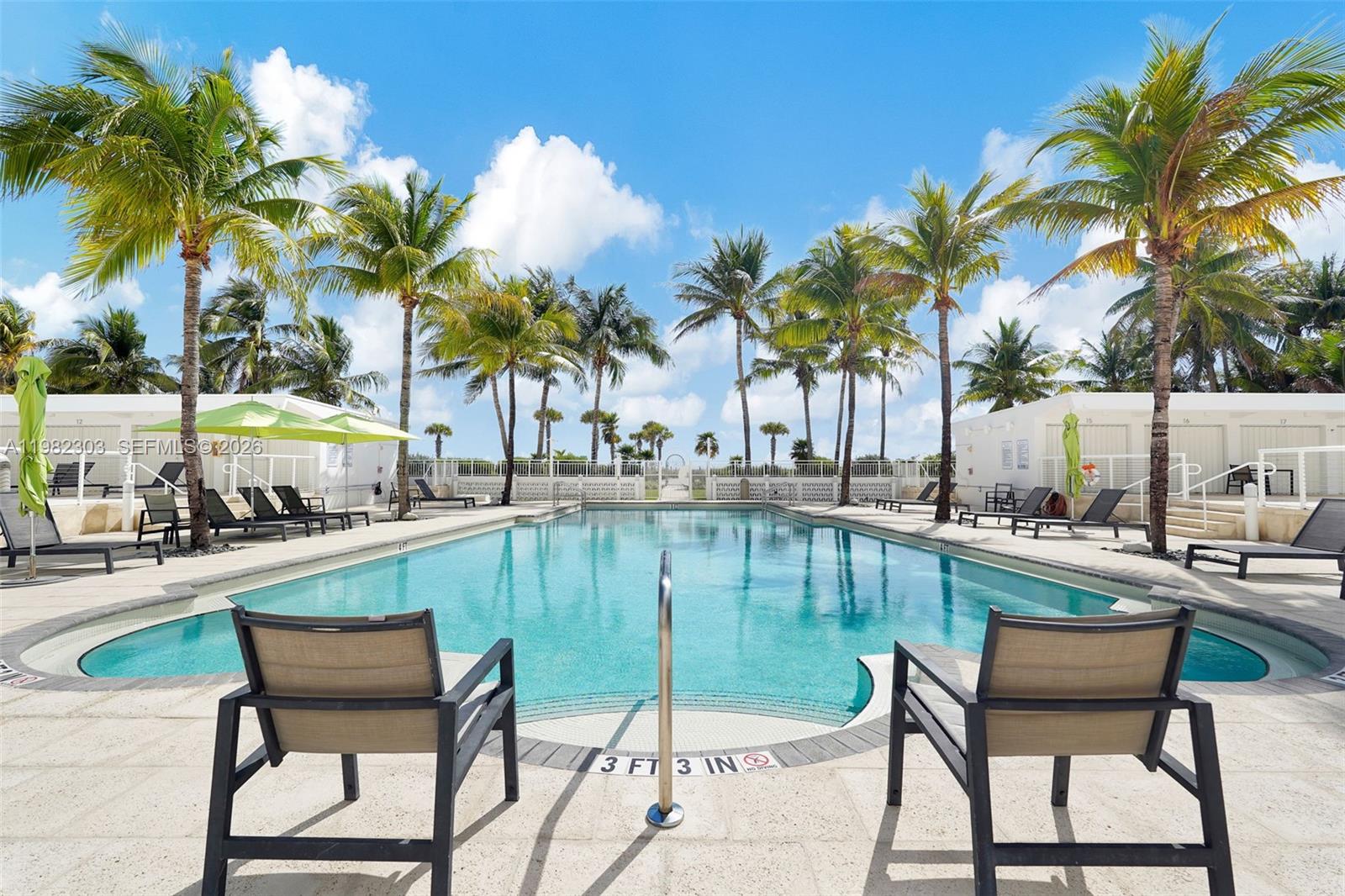 A rectangular swimming pool is surrounded by lounge chairs, palm trees, and white cabanas — 4925 Collins Ave # 4A, Miami Beach FL 33140, MIAMI BEACH, FL