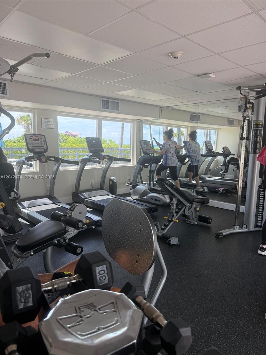 This gym features treadmills, an elliptical machine, weight equipment, and large windows with ocean views — 5005 Collins Ave # 1104, Miami Beach FL 33140, MIAMI BEACH, FL