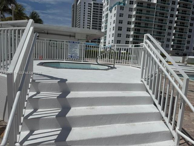 Concrete steps lead up to a small, elevated hot tub surrounded by white metal railings — 5005 Collins Ave # 1104, Miami Beach FL 33140, MIAMI BEACH, FL