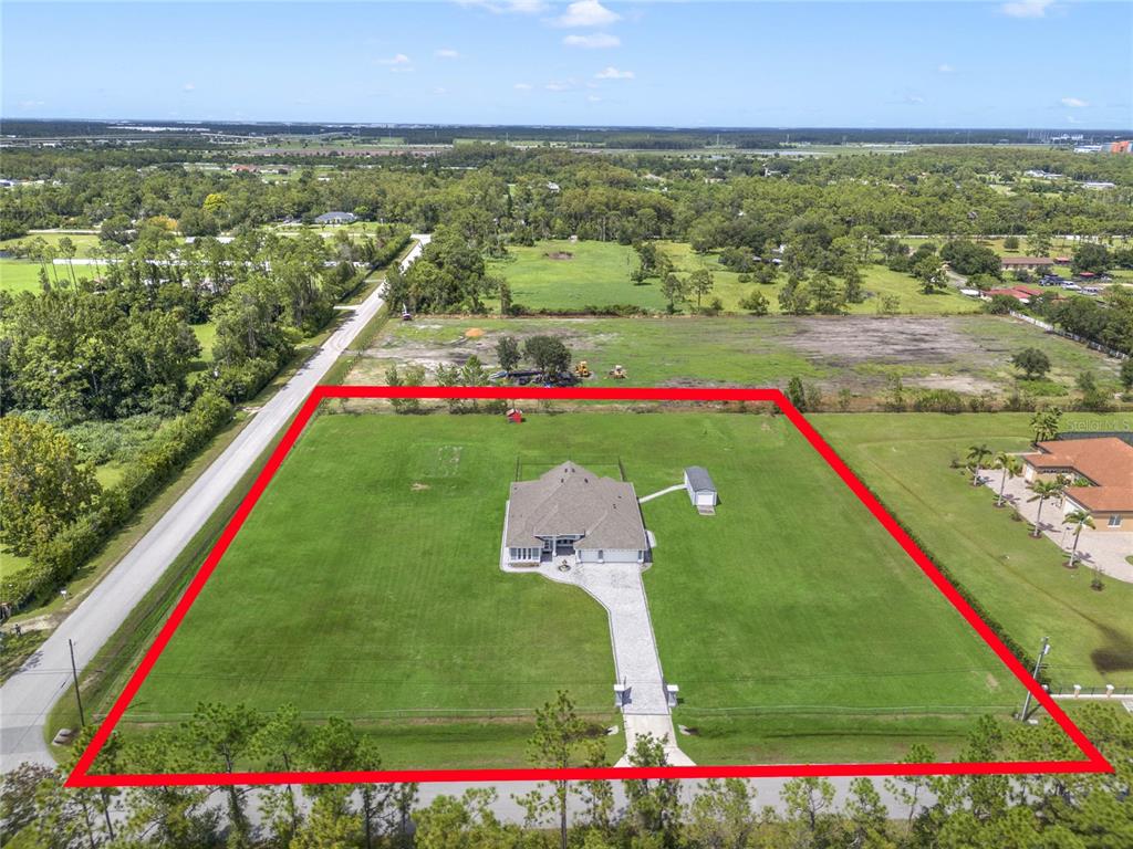 An aerial view shows a house with a paved driveway on a large, fenced lot — 6607 WHISPERING PINES ROAD, ORLANDO, FL