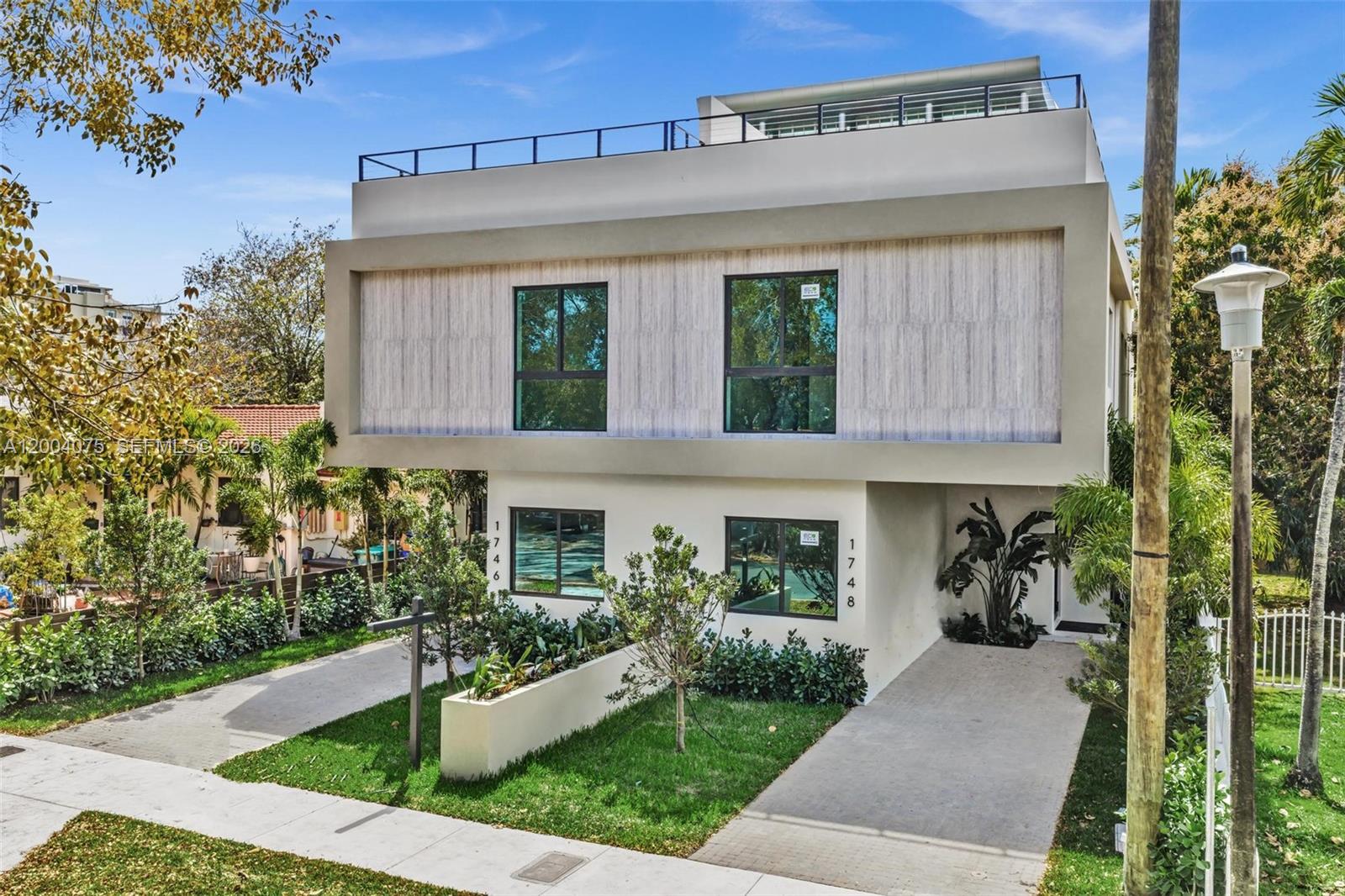 A modern two-story duplex building features a flat roof, light-colored facade, and two driveways — 1748 SW 21st Ter, Miami FL 33145, MIAMI, FL