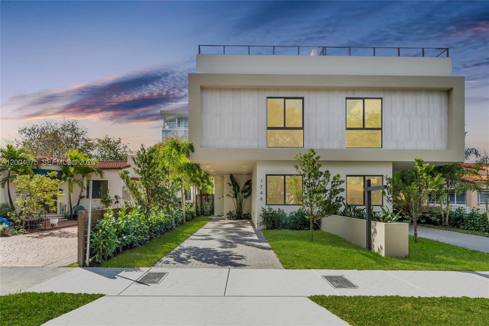 A modern two-story house with a flat roof and a paved driveway stands at dusk — 1748 SW 21st Ter, Miami FL 33145, MIAMI, FL