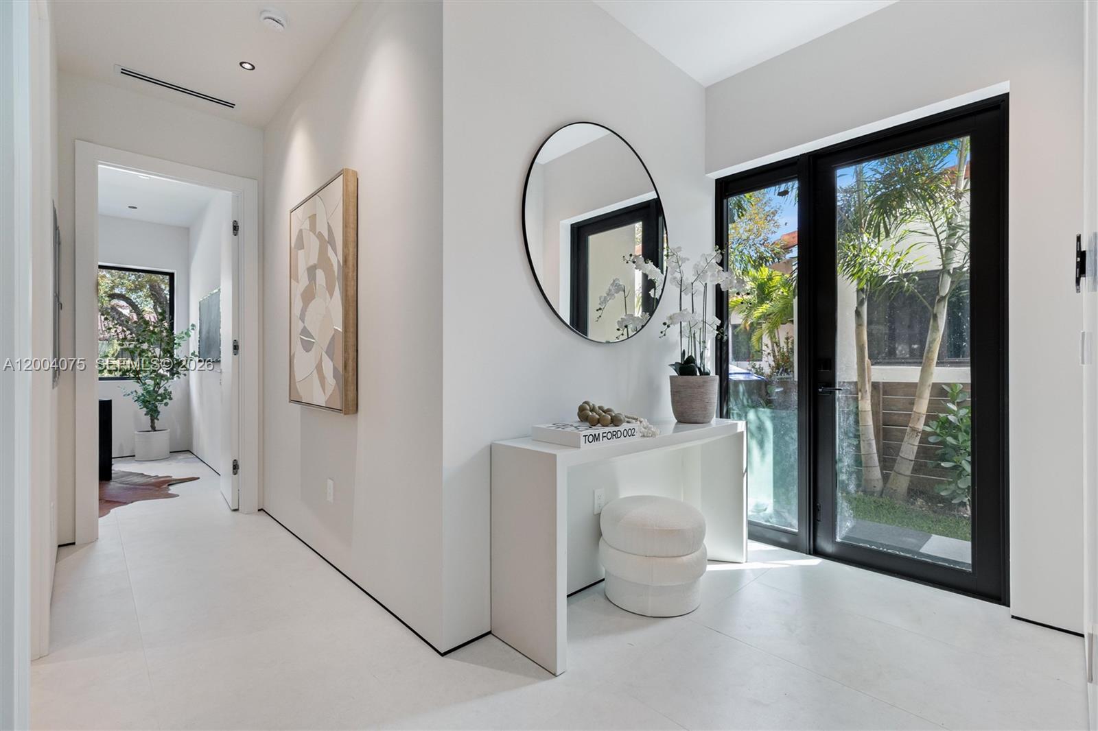 A modern white entryway features a console table, round mirror, and glass door to outdoors — 1748 SW 21st Ter, Miami FL 33145, MIAMI, FL