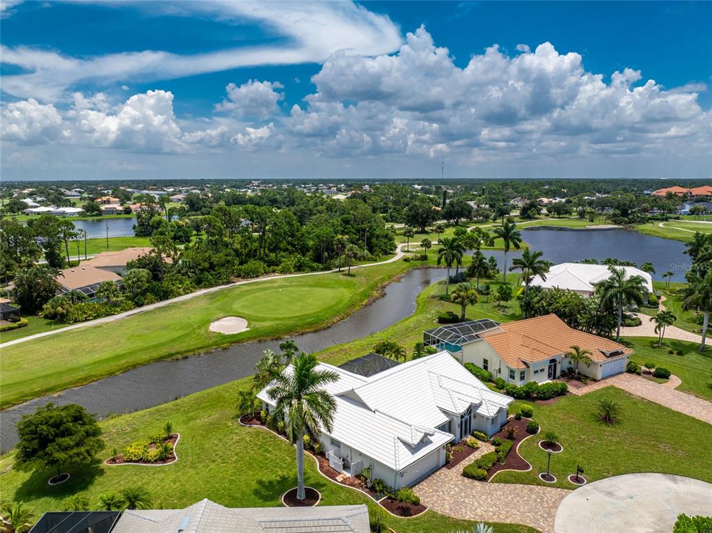 An aerial view of a residential neighborhood featuring houses, a golf course, and a pond — 6011 KEY LARGO CIRCLE, PUNTA GORDA, FL