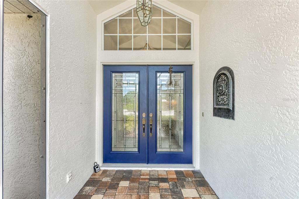 A front entryway features blue double doors with glass inserts and a stone-tiled floor — 6011 KEY LARGO CIRCLE, PUNTA GORDA, FL
