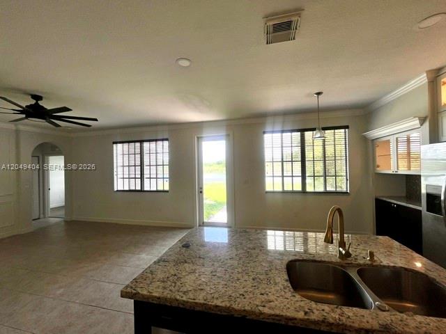 A kitchen island with a granite countertop and double sink overlooks an open living area — 27448 SW 143rd Ct, Homestead FL 33032, HOMESTEAD, FL
