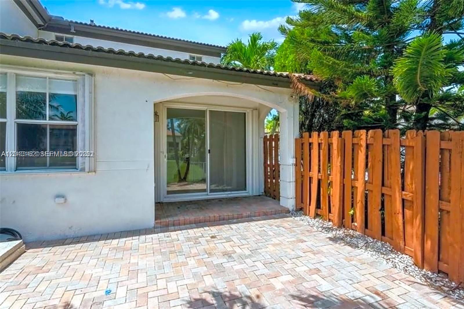A paved patio sits outside a sliding glass door under a covered porch area — 11497 NW 78th Ter, Doral FL 33178, DORAL, FL