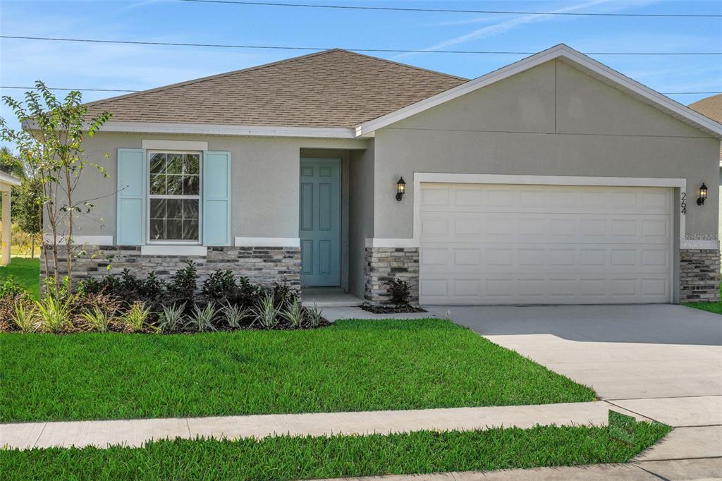 A single-story house with a light gray exterior, stone veneer accents, and a blue front door — 1040 LUKE AVENUE, WINTER HAVEN, FL