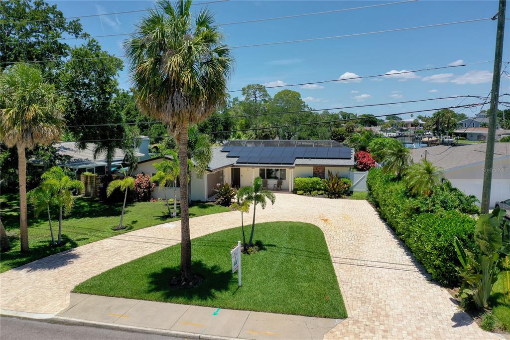 A single-story house with solar panels on the roof and a paved driveway — 5119 VENETIAN BOULEVARD NE, ST PETERSBURG, FL