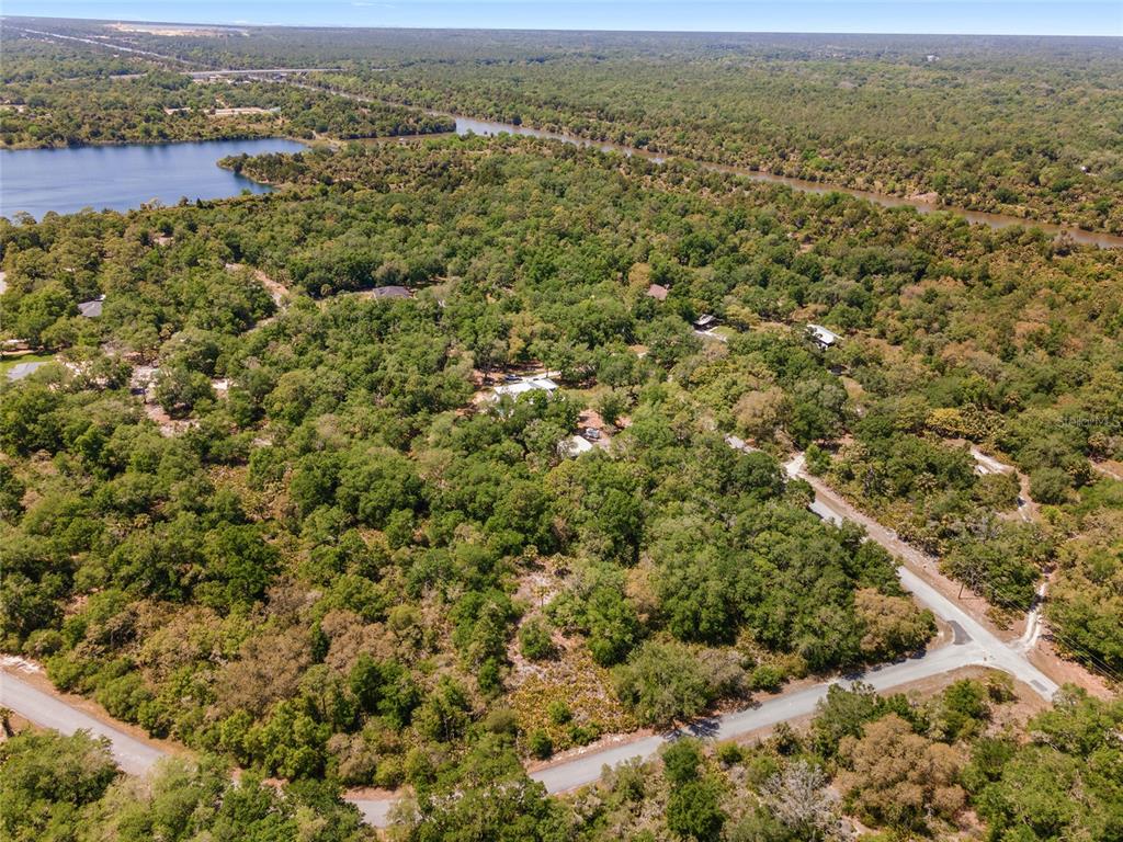 An aerial view shows a wooded property with a house, a lake, and winding roads — 12577 W ROSEMARY PLACE, CRYSTAL RIVER, FL