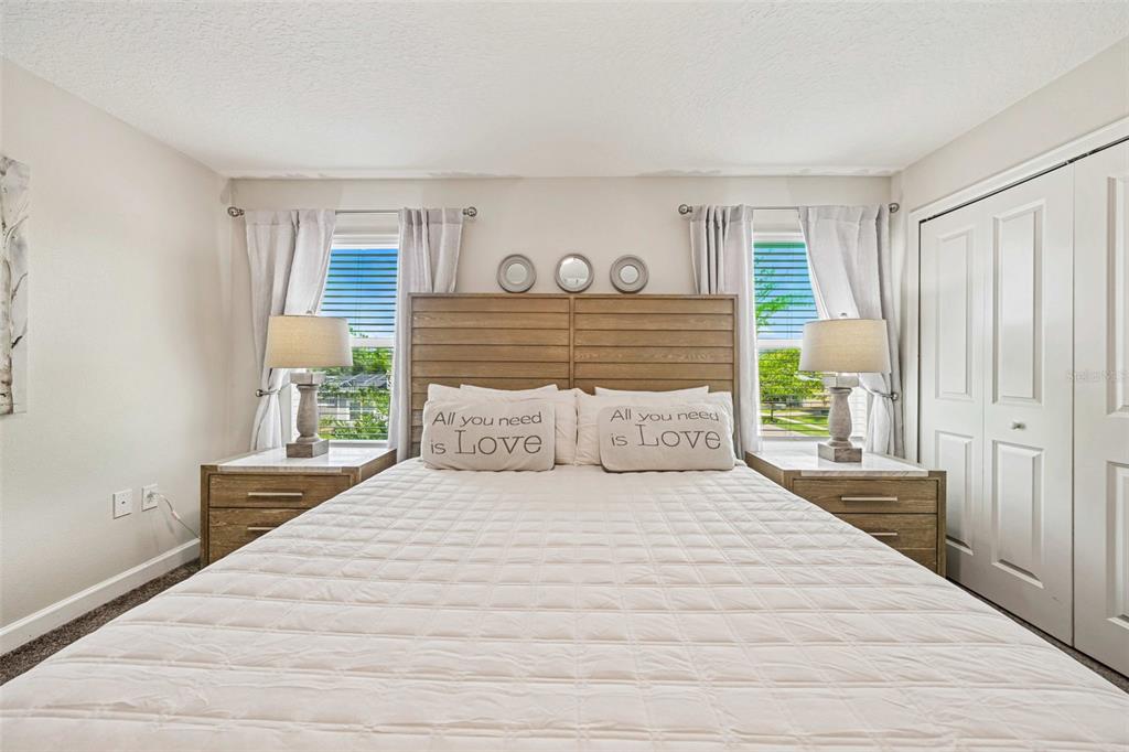 A bedroom features a wooden headboard, two nightstands with lamps, and a white quilt — 218 OCEAN COURSE AVENUE, DAVENPORT, FL