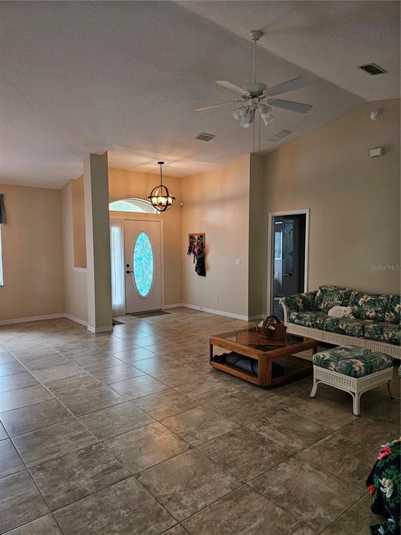 A living room with tiled floors, a ceiling fan, and an entryway with a front door — 5280 SW 88TH PLACE, OCALA, FL