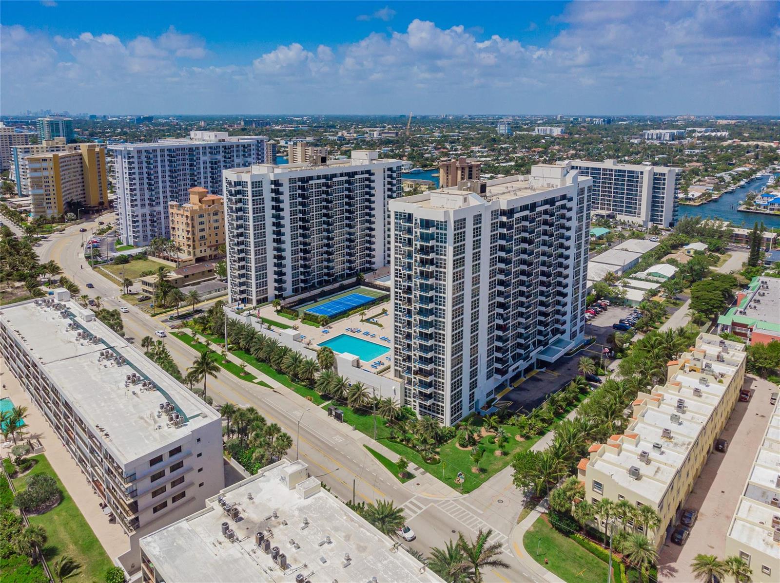 An aerial view shows two tall white apartment buildings with a pool and tennis court — 525 N Ocean Boulevard # 1422, Pompano Beach FL 33062, POMPANO BEACH, FL