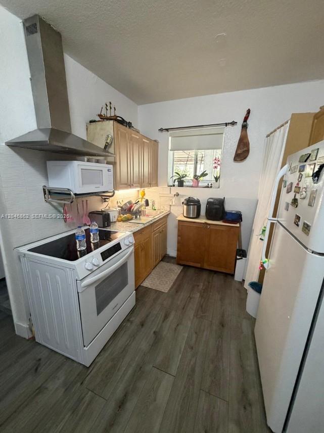 This kitchen features light wood cabinets, a white stove, a stainless range hood, and wood-look flooring — 1021 NW 3rd St # 106, Miami FL 33128, MIAMI, FL