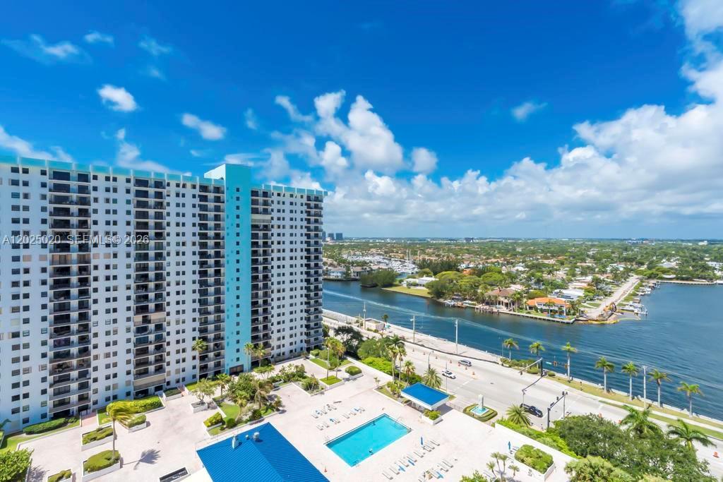 An aerial view shows a high-rise apartment building with a swimming pool and nearby waterway — 1201 S Ocean Dr # 2003N, Hollywood FL 33019, HOLLYWOOD, FL