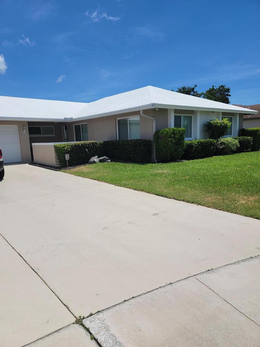 A single-story house with a white roof, beige stucco walls, and a concrete driveway — 27 Vista Del Rio, Boynton Beach FL 33426, BOYNTON BEACH, FL