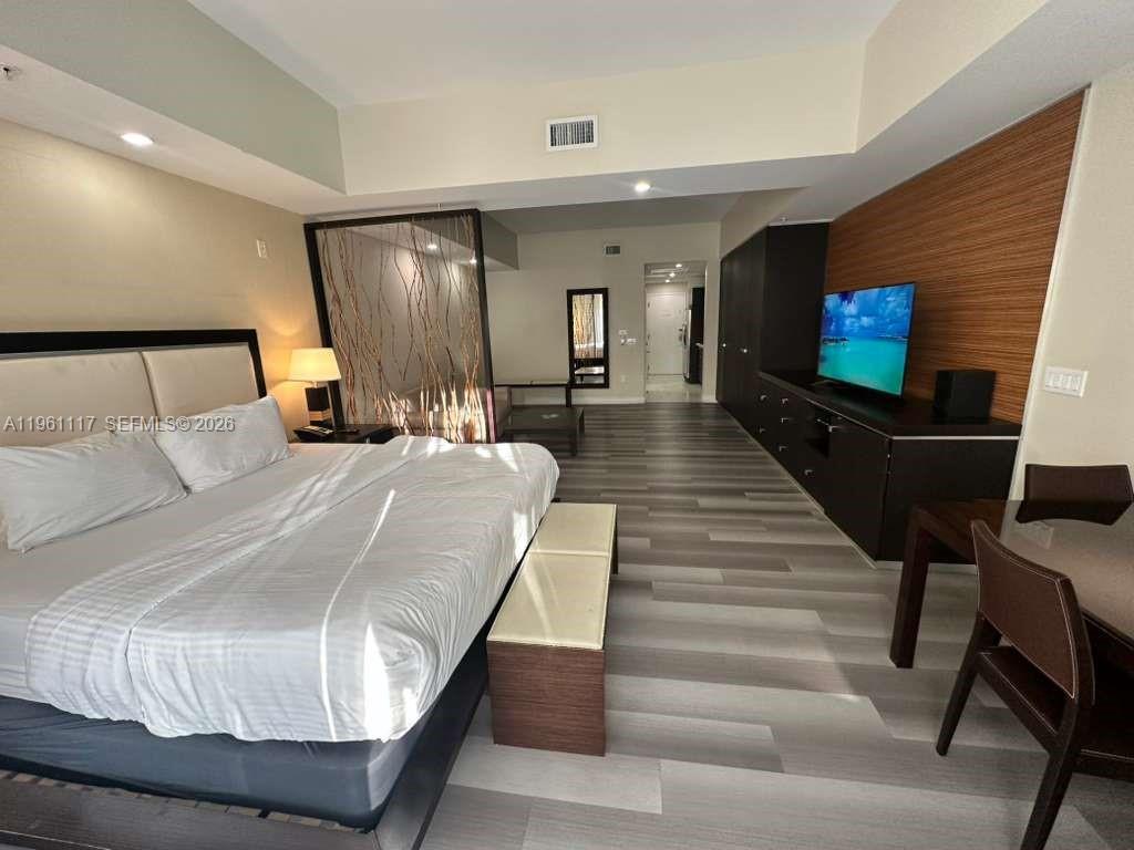 A narrow kitchen features stainless steel appliances, dark cabinetry, and light-colored tile flooring — 5300 NW 87th Ave # 910, Doral FL 33178, DORAL, FL