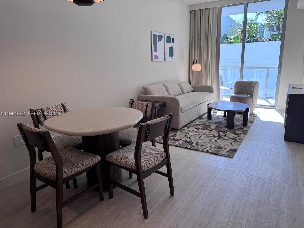 A dining area with a round table and chairs sits beside a living room — 1611 SW 2nd Av # 306, Miami FL 33129, MIAMI, FL