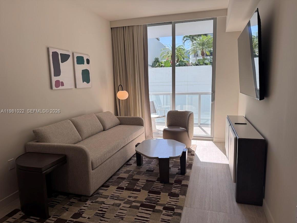 A living room features a sofa, patterned rug, coffee table, and a sliding glass door — 1611 SW 2nd Av # 306, Miami FL 33129, MIAMI, FL