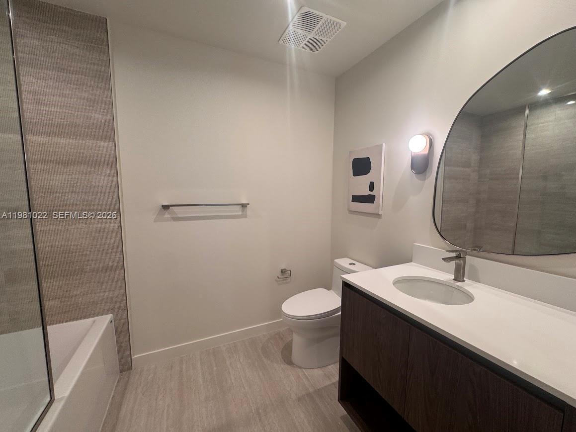 This modern bathroom features a dark wood vanity, white countertop, and a glass-enclosed shower — 1611 SW 2nd Av # 306, Miami FL 33129, MIAMI, FL