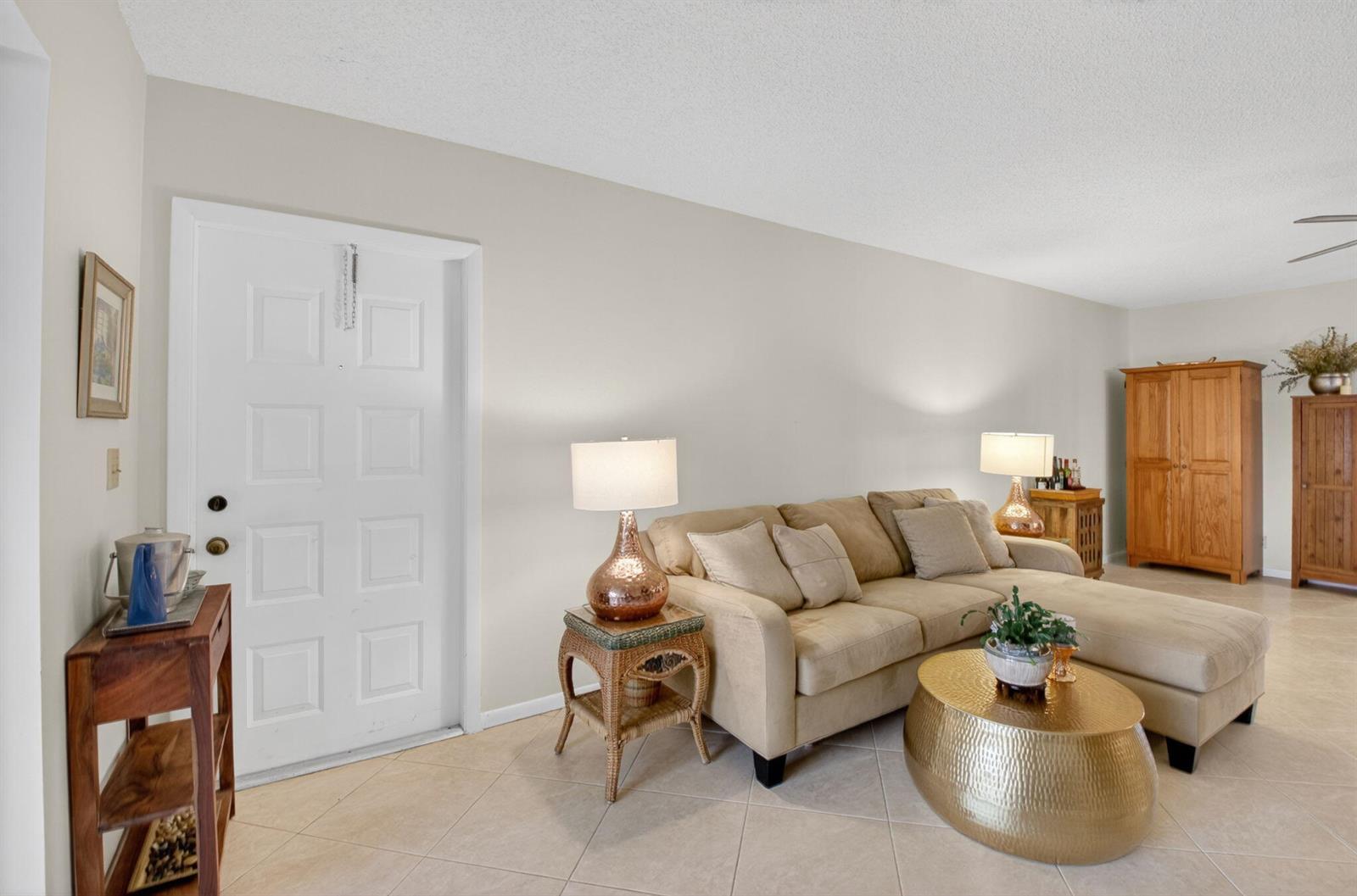 A living room features a beige sectional sofa, a gold coffee table, and a white door — 14579 Canalview Drive # B, Delray Beach FL 33484, DELRAY BEACH, FL