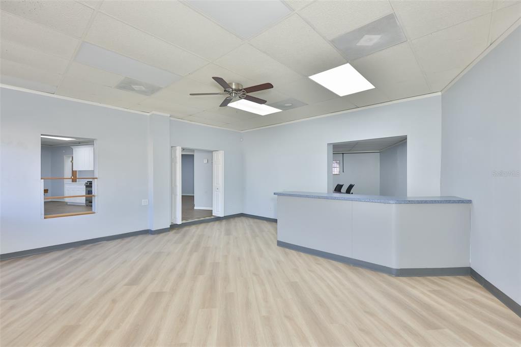 An interior view of a commercial space featuring light-colored flooring, a reception counter, and ceiling tiles — 1801 28TH STREET N, ST PETERSBURG, FL