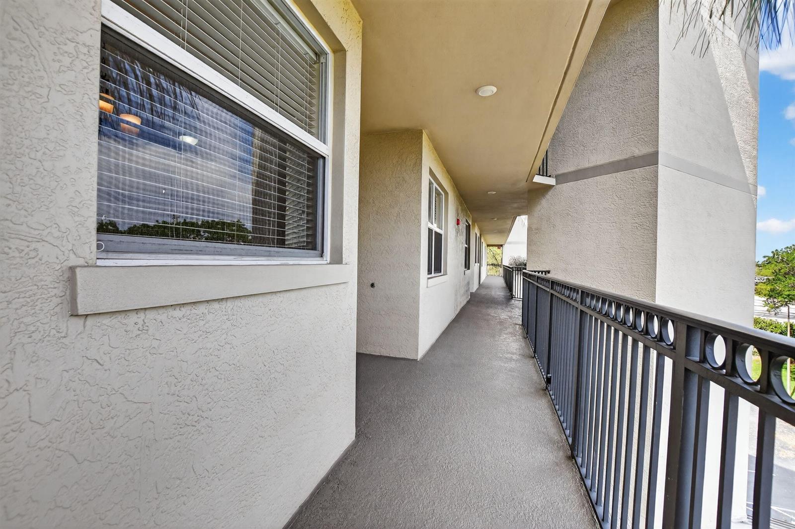 An outdoor apartment balcony with a metal railing and beige stucco walls — 26 Royal Palm Way # 403, Boca Raton FL 33432, BOCA RATON, FL