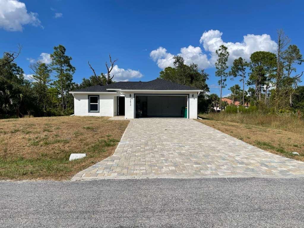 A single-story white house with a dark roof and a paved driveway — 17512 POSTON AVENUE, PORT CHARLOTTE, FL