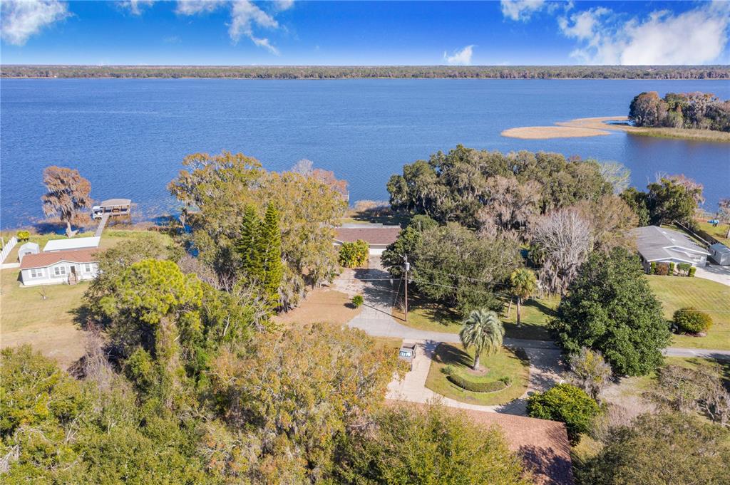 An aerial view shows a house with a long driveway near a large lake — 436 JEFFERY LANE, HAINES CITY, FL